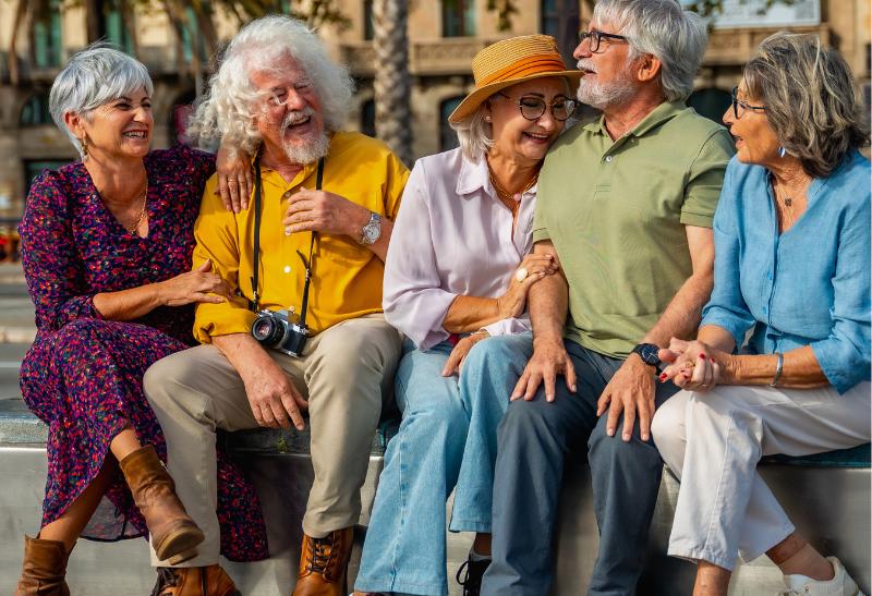 Skupina ľudí na sediacia na lavičke.