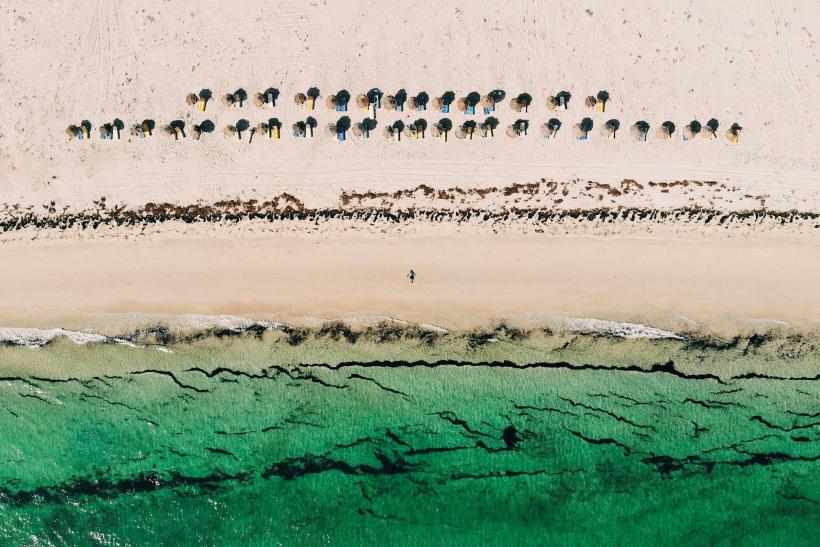Smaragdové more a slnečníky na pláži na ostrove Djerba.