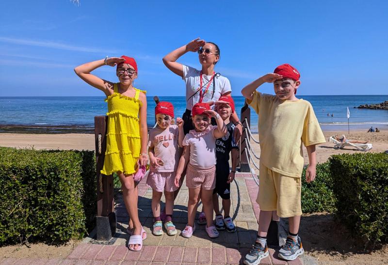 Deti a animátorka Planet FUN na pláži v hoteli Shangri-La Barr Al Jissah - Al Waha v Ománe.