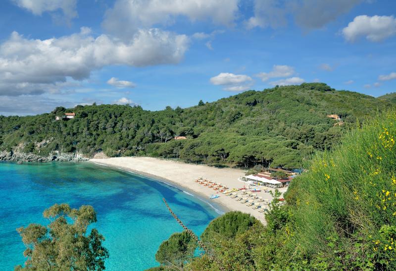 Krásna pláž Fetovaia so slnečníkmi a zeleňou v okolí.