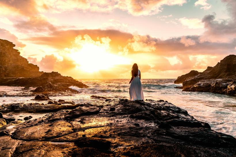 Žena pri mori pri západe slnka.