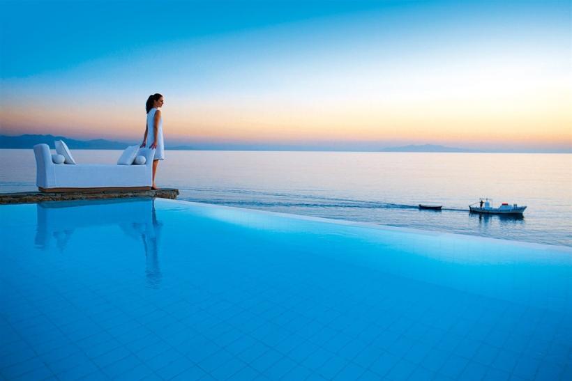 Žena pri bazéne s výhľadom na more.