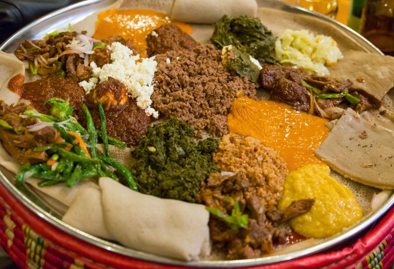 Zeleninové, mäsové jedlo s kari a s tenkým chlebom injera.