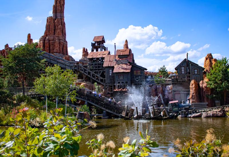 Skalná hora a drevené domy pri vode v Disneylande v Paríži.