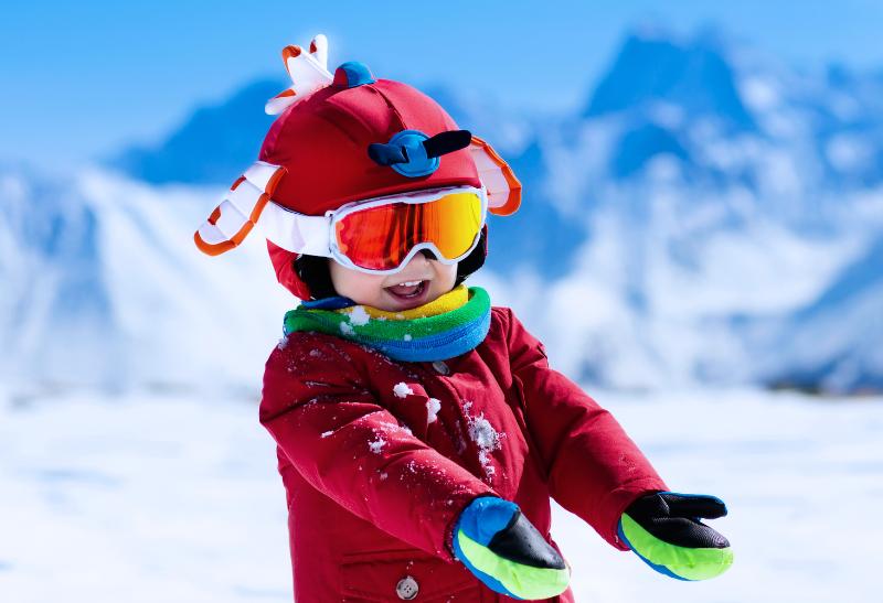 Malé dieťa v lyžiarskej výstroji na snehu.