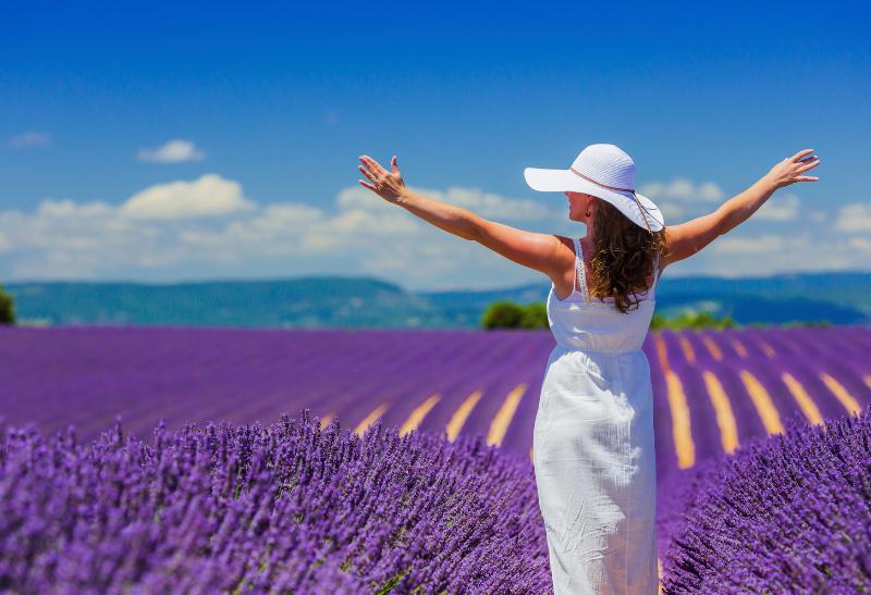 Žena v bielych šatách na levanduľovom poli v Provensálsku.