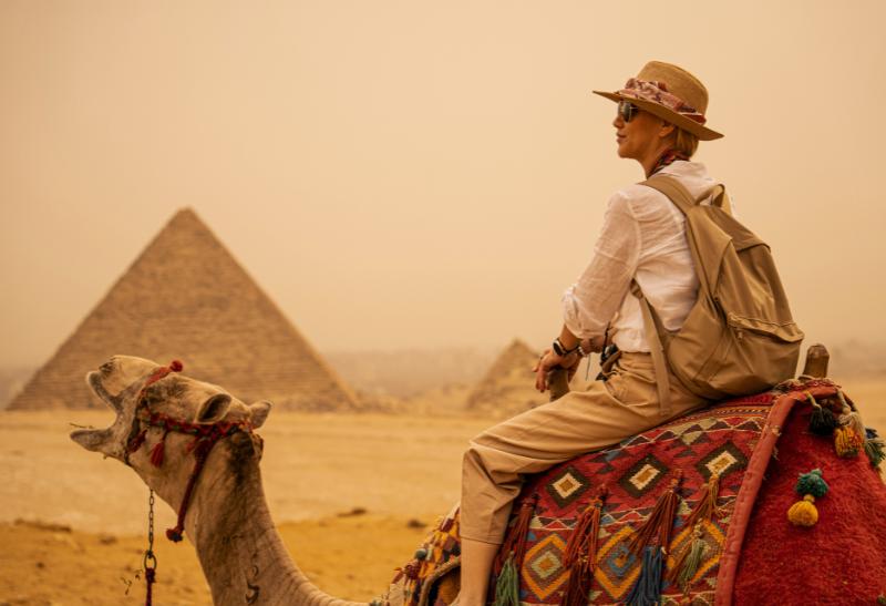 Žena na ťave pri pyramíde v Gíze.