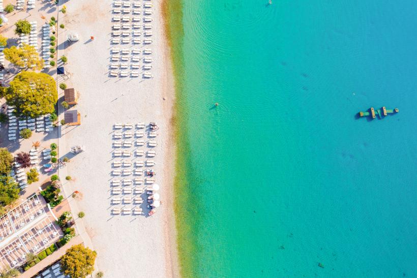 Pláž a tyrkysové more v zátoke Maslinica pri meste Rabac.