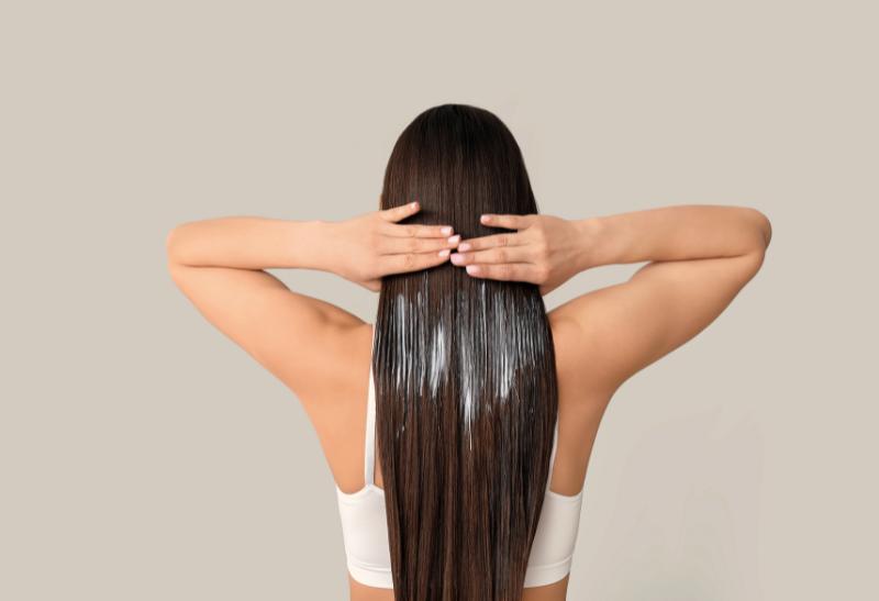 Žena s dlhými vlasmi a kokosovou kúrou.