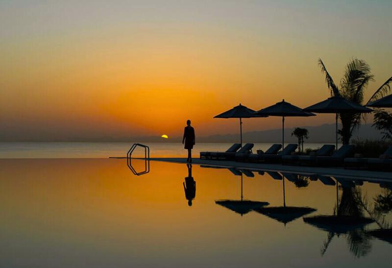 Bazén pri západe slnka pred hotelom Kempinski v Ománe.