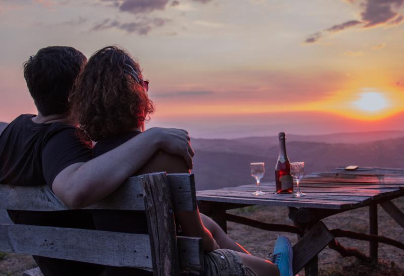 Dvojica na kopci s výhľadom na západ slnka.