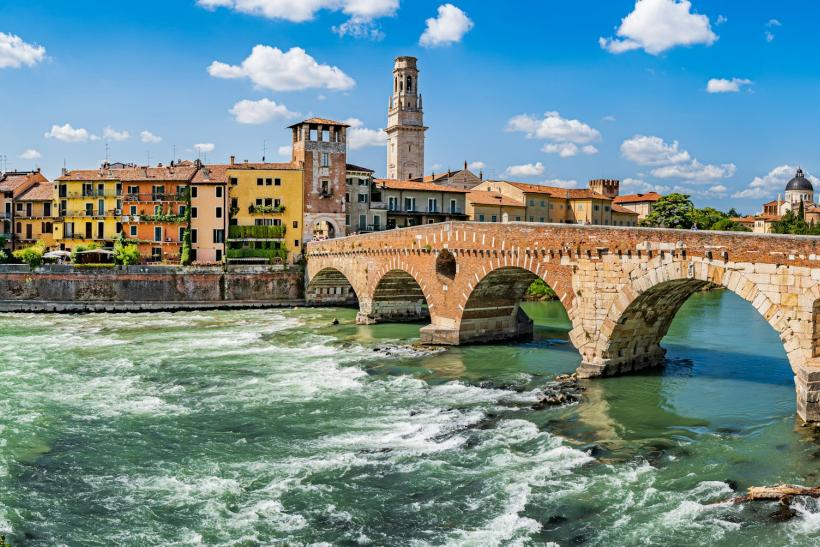 Farebné domy a most pri rieke vo Verone.