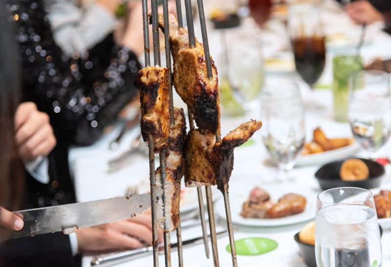 Brazílska churrascaria, stolovanie a grilované mäso.