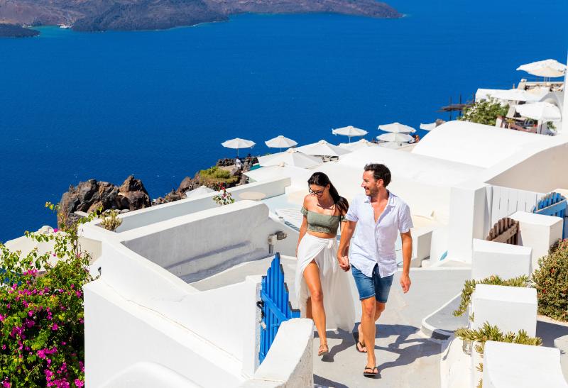 Pár prechádzajúci sa vo Fira na Santorini počas dňa.