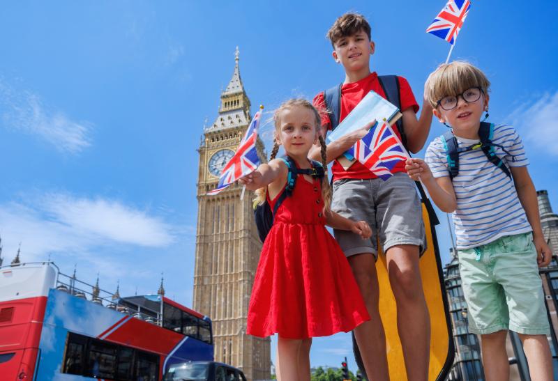 Tri deti s vlajkami v Londýne na ulici.