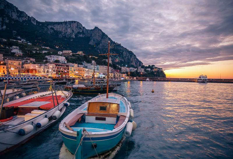 Prístav s loďami a farebné domčeky na ostrove Capri.