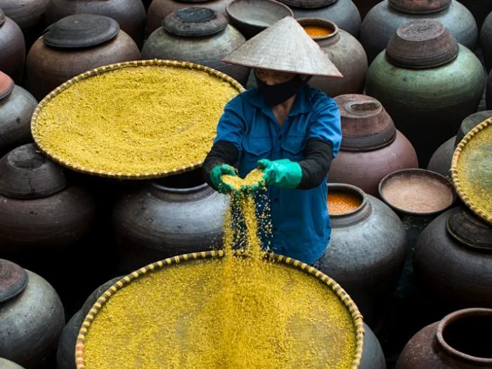 Pracujúci Vietnamec pri spracovaní sóje na výrobu sójovej omáčky.