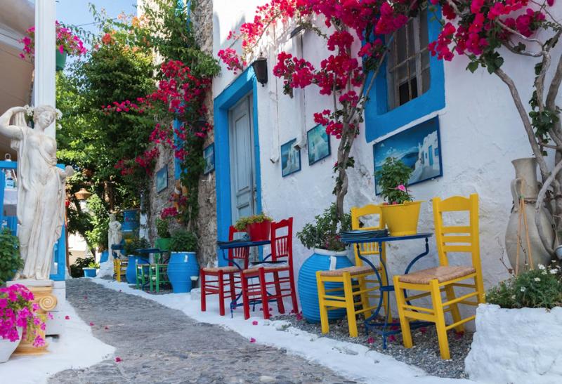 Farebné uličky so stolom a stoličkami v meste Kos.