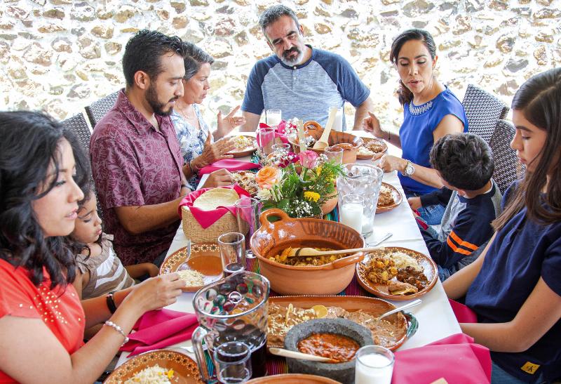 Rodina spoločne obeduje za stolom.