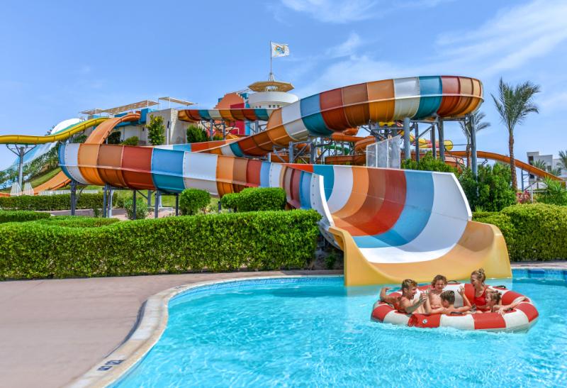 Rodina v bazéne pri toboganoch.