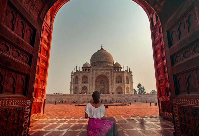 Žena stojaca v bráne pred chrámom Taj Mahal.