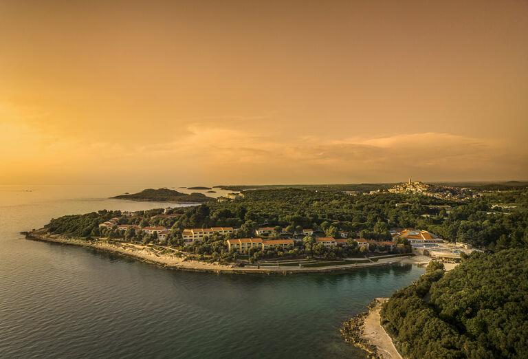 Rozmanitá Istria, krásne pobrežie, zeleň a oranžový západ slnka. Chorvátsko.