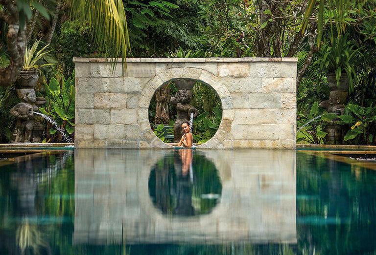 Žena kúpajúca sa v bazéne a bujná zeleň v okolí. Ostrov Bali.