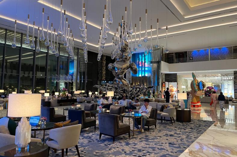 Lobby s pohodlnými kreslami, výťahmi a akváriom v hoteli Atlantis The Royal.