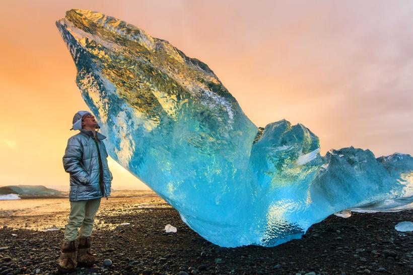 muž stojaci pri ľadovci na Islande