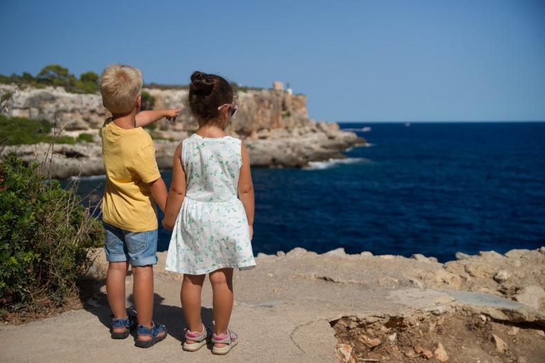 Dve malé deti pozerajúce sa na more.