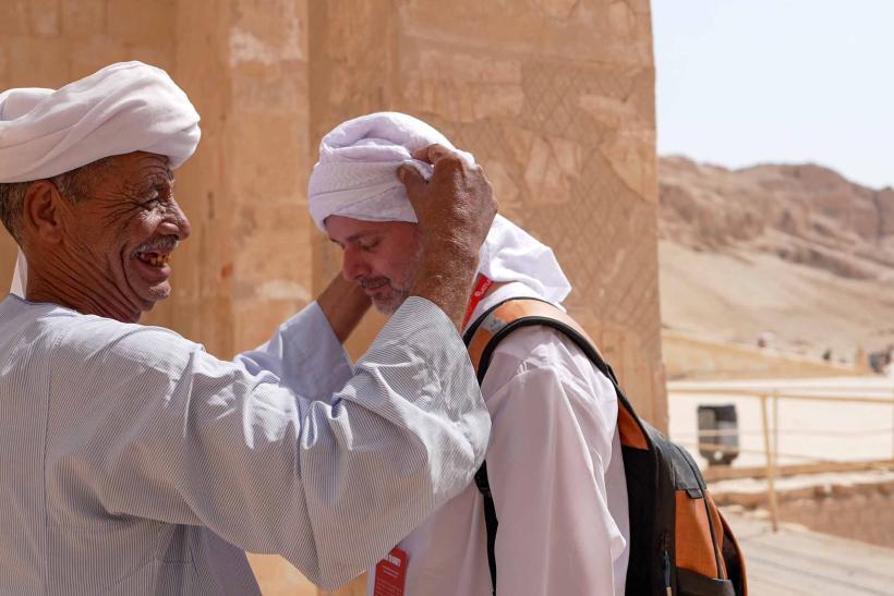 Egypťan robí turistovi turban.