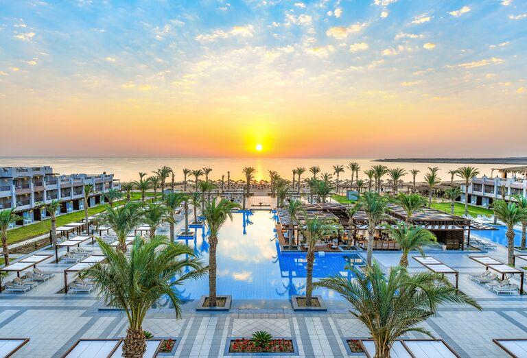 Červené more s pieskovou plážou, plamy okolo bazéna a ubytovanie hotela Iberotel Costa Mares v Egypte.