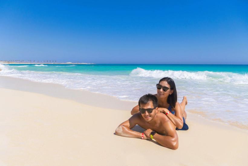 Párik dovolenkárov ležia na bielej pláži v Marsa Matrouh, Egypt.
