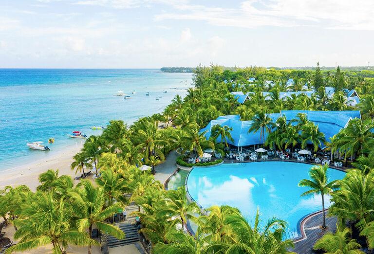 Nádherná piesková pláž s palmami pred hotelom Victoria Beachcomber. Maurícius.