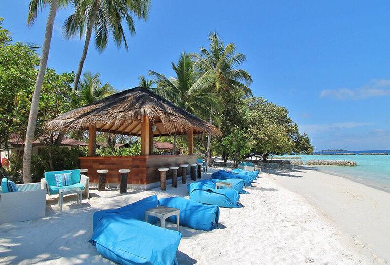 Piesková pláž s modrými tuli vakmi, barom a plamami v hoteli Kurumba Maldives