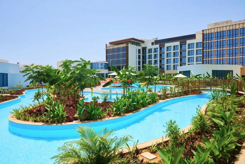 Bazén a budova hotela Millennium Resort Salalah.