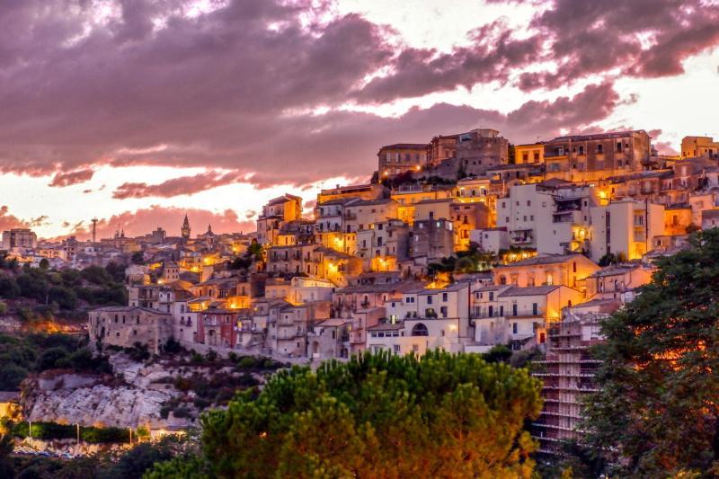 Mesto Ragusa medzi údoliami vo večernom svetle.