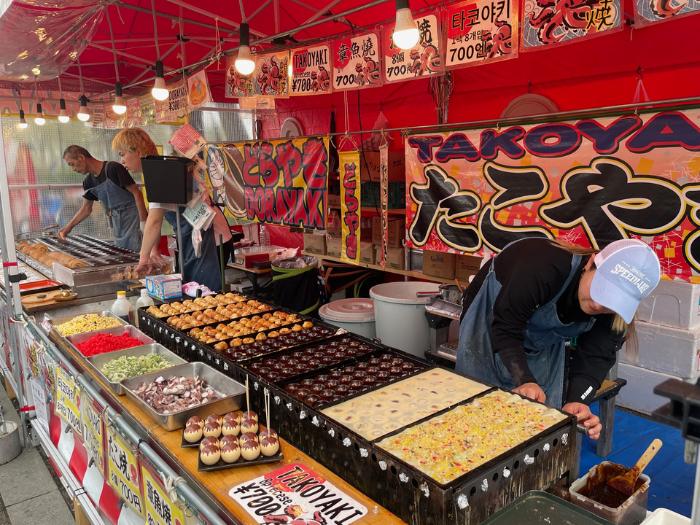 Stánok s občerstvením a predávajúci Japonci sladké a slané pokrmy.
