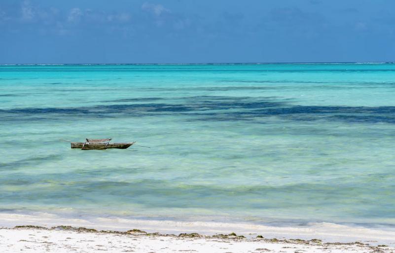 Biela piesková pláž a tyrkysový oceán v Jambiani. Zanzibar
