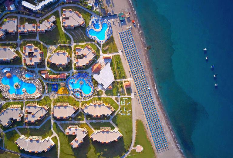 Pohľad na hotel Lindos Princess, na pláž, záhradu a tyrkysové more na ostrove Rodos.