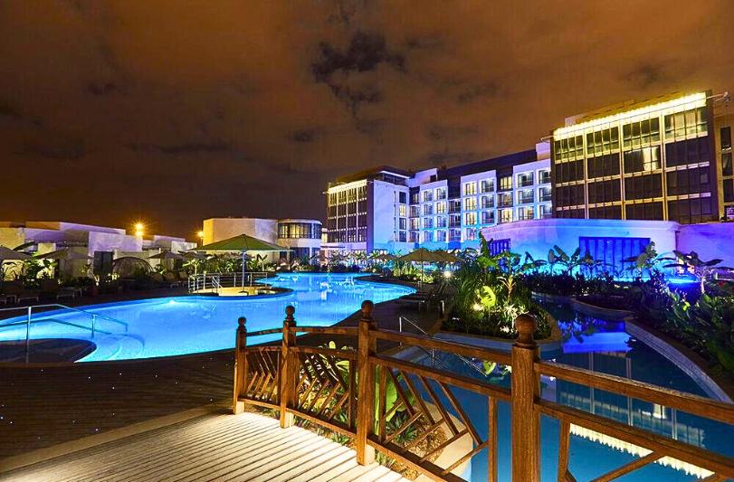 Večerný vysvietený areál hotela Millennium Resort Salalah v modernom štýle. Omán.