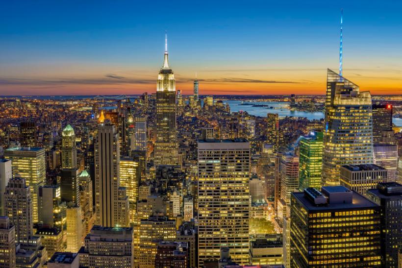 Vysvietený New York s výškovými stavbami počas západu slnka. USA