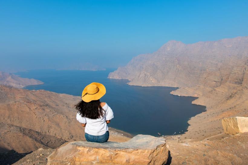 žena so žltým klobúkom si užíva pohľad na ománsky polostrov Musandam
