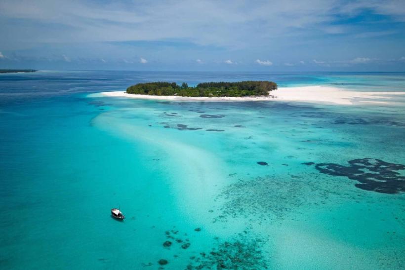 Tyrkysová farba mora a malý ostrov pri brehoch Zanzibaru.