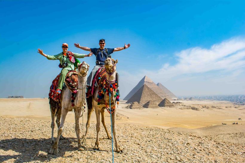 Pyramídy v Gíze a dvaja turisti na ťave.