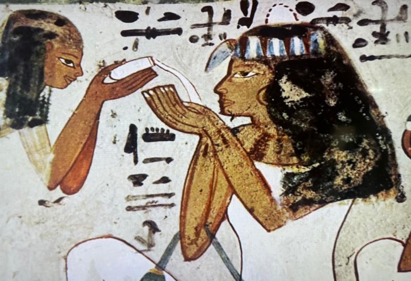 Maľovaný reliéf s egyptskou ženou, ktorá vonia tekutú vôňu.