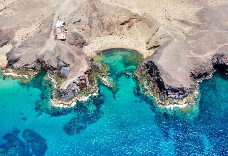 Playa del Papagayo - skalné pobrežie a piesočnatá pláž v malom zálive.
