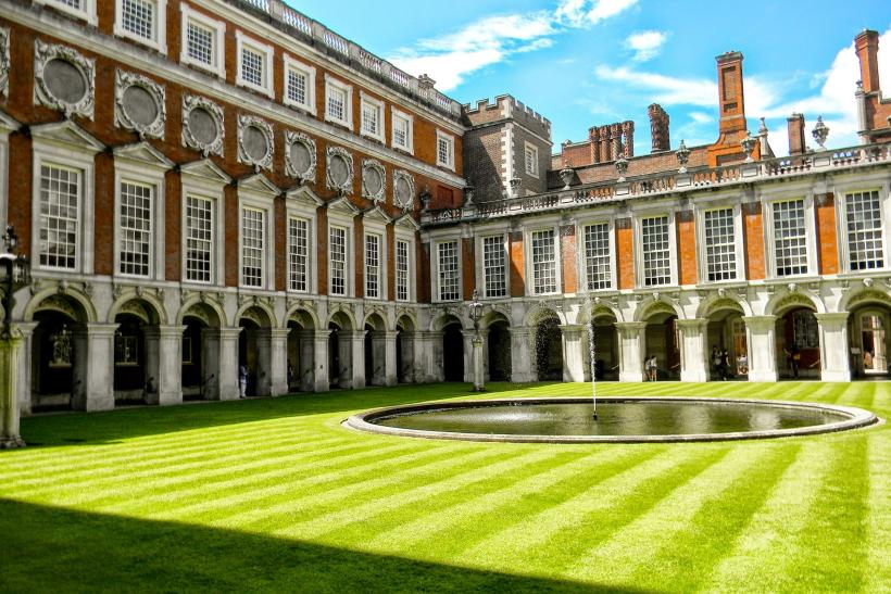 Palác a zelený trávnik v Hampton Court v Anglicku.