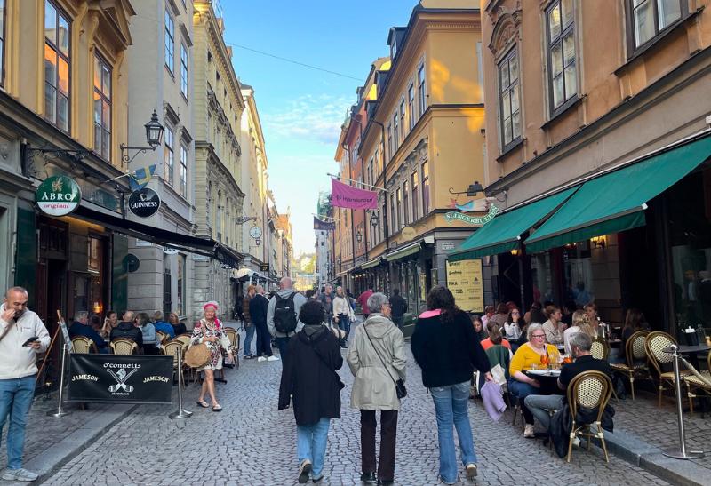 Ľudia kráčajúci v historickej štvrti Gamla Stan v Štokholme počas bielej noci.