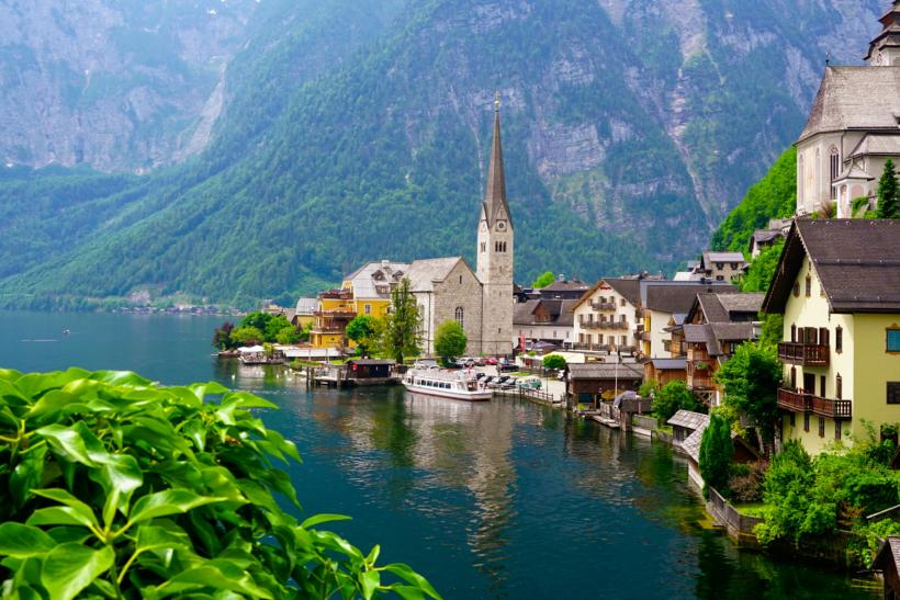 Rozkvitnuté mesto Hallastatt s jazerom a domami.